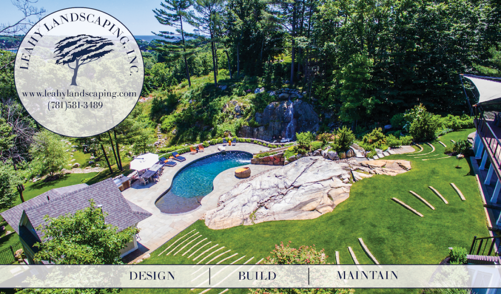 Marblehead, MA luxury landscaping. Leahy Landscaping example with a green lawn, stone patio, and pool