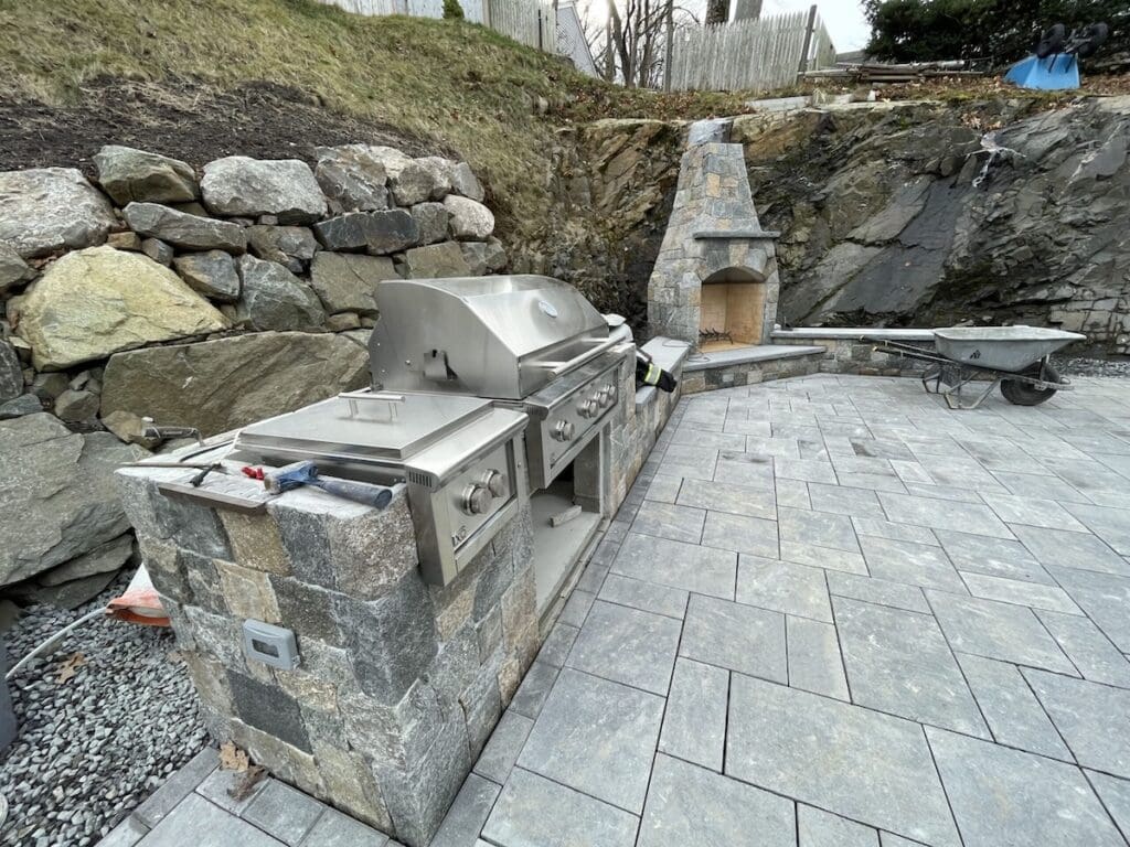 hardscaping example by a landscaper in Swampscott, MA with a stone patio and outdoor kitchen